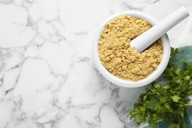 Photo of Mortar with aromatic mustard powder and parsley on white marble table, flat lay. Space for text