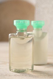 Photo of Mini bottles of cosmetic products on white wooden table