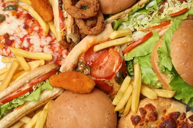French fries, pizza and other fast food as background, top view