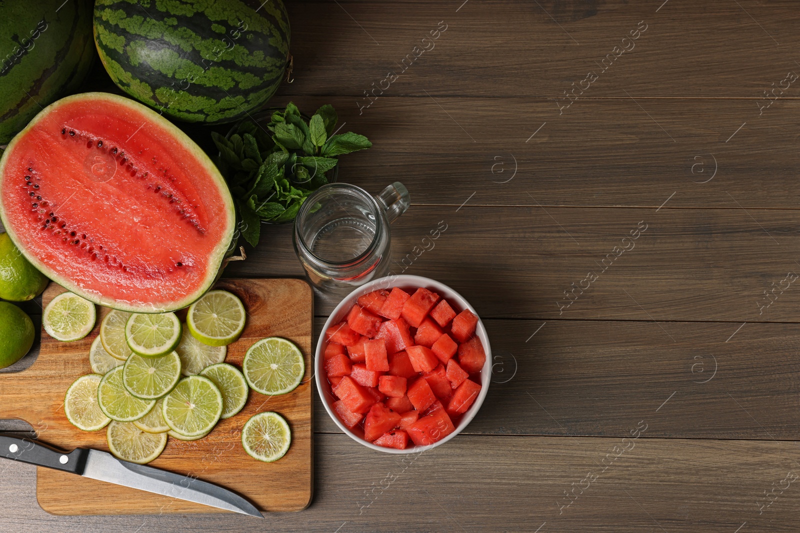 Photo of Fresh ingredients for making watermelon drink with lime on wooden table, above view. Space for text