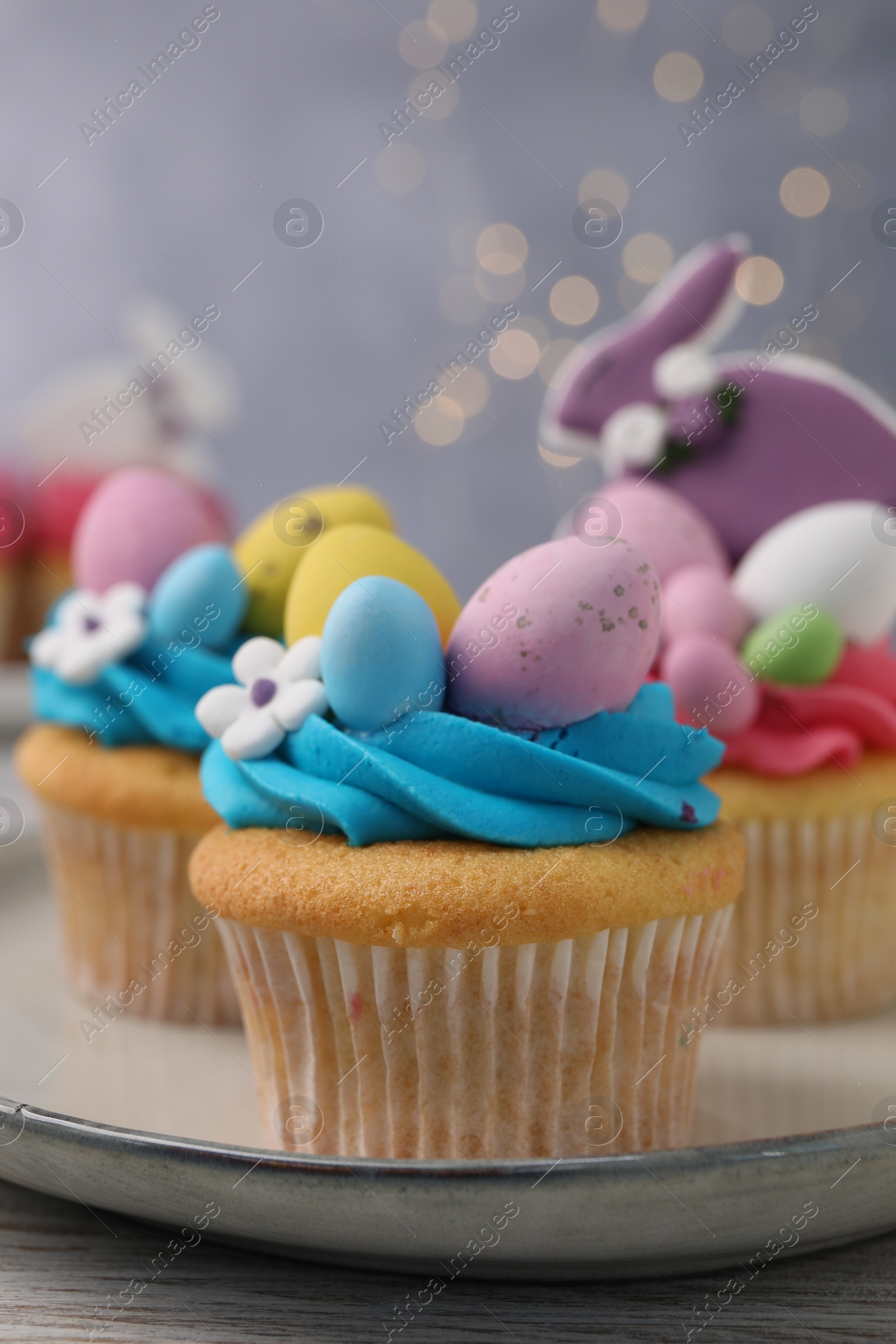 Photo of Tasty decorated Easter cupcakes on wooden table, closeup