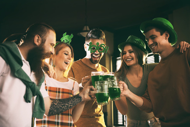 Photo of Group of friends toasting with green beer in pub.St. Patrick's Day celebration