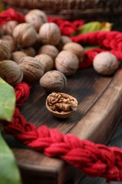 Photo of Net bag with walnuts on wooden table, closeup