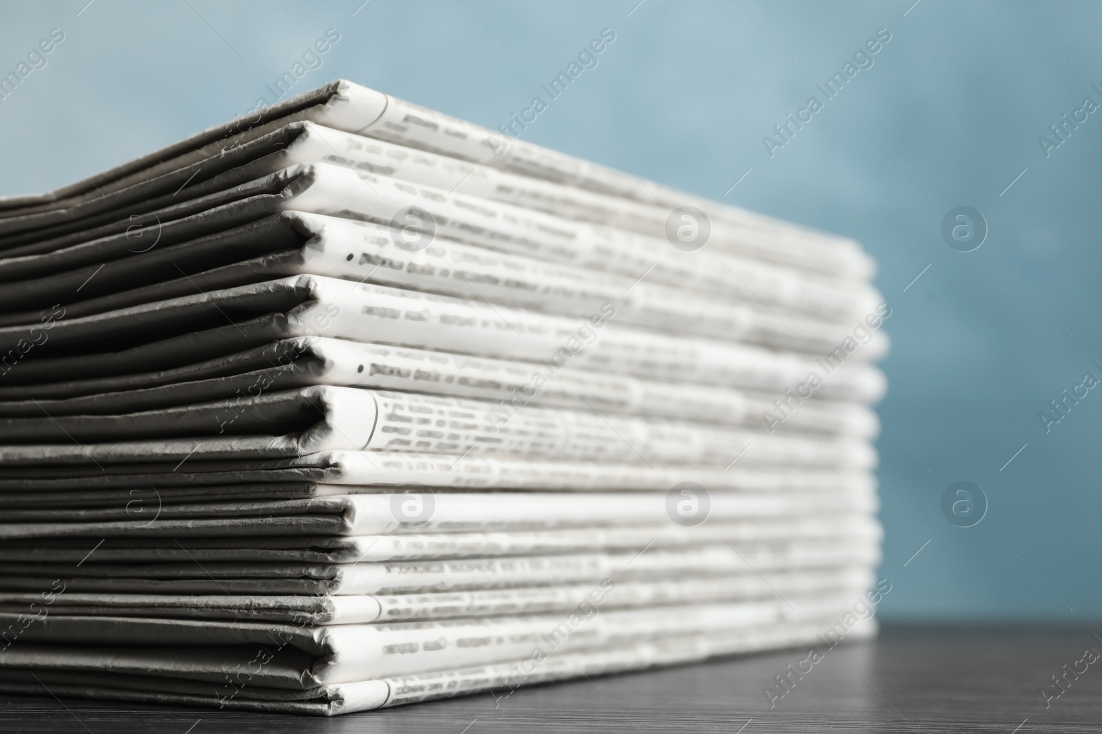 Photo of Stack of newspapers on blue background, closeup. Journalist's work