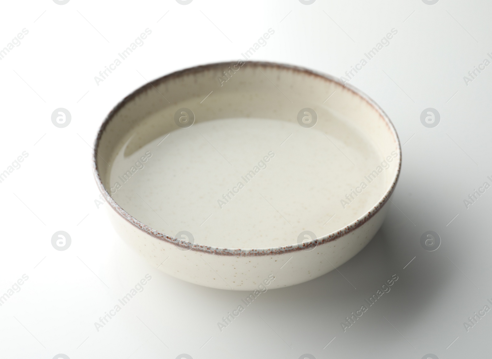 Photo of Beige bowl full of water on white background