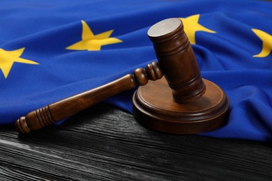 Photo of Judge's gavel and flag of European Union on black wooden table