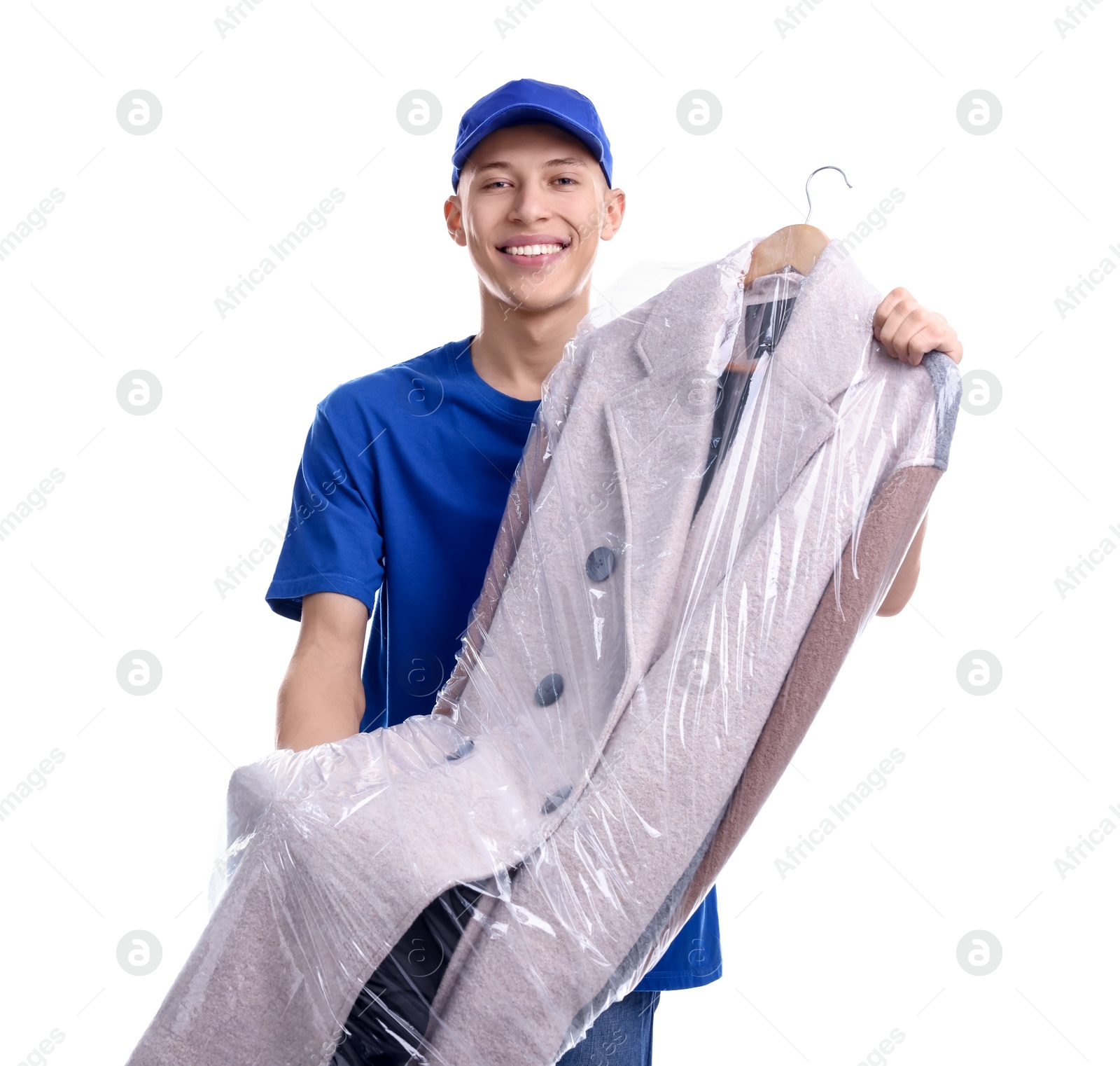 Photo of Dry-cleaning delivery. Happy courier holding coat in plastic bag on white background