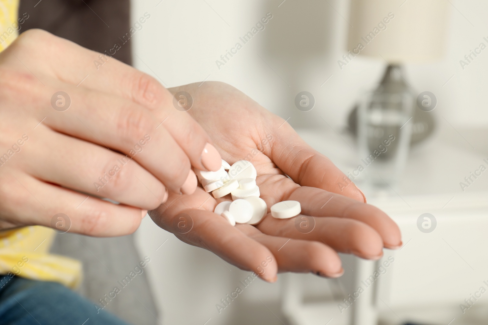 Photo of Woman taking medicine indoors, closeup view