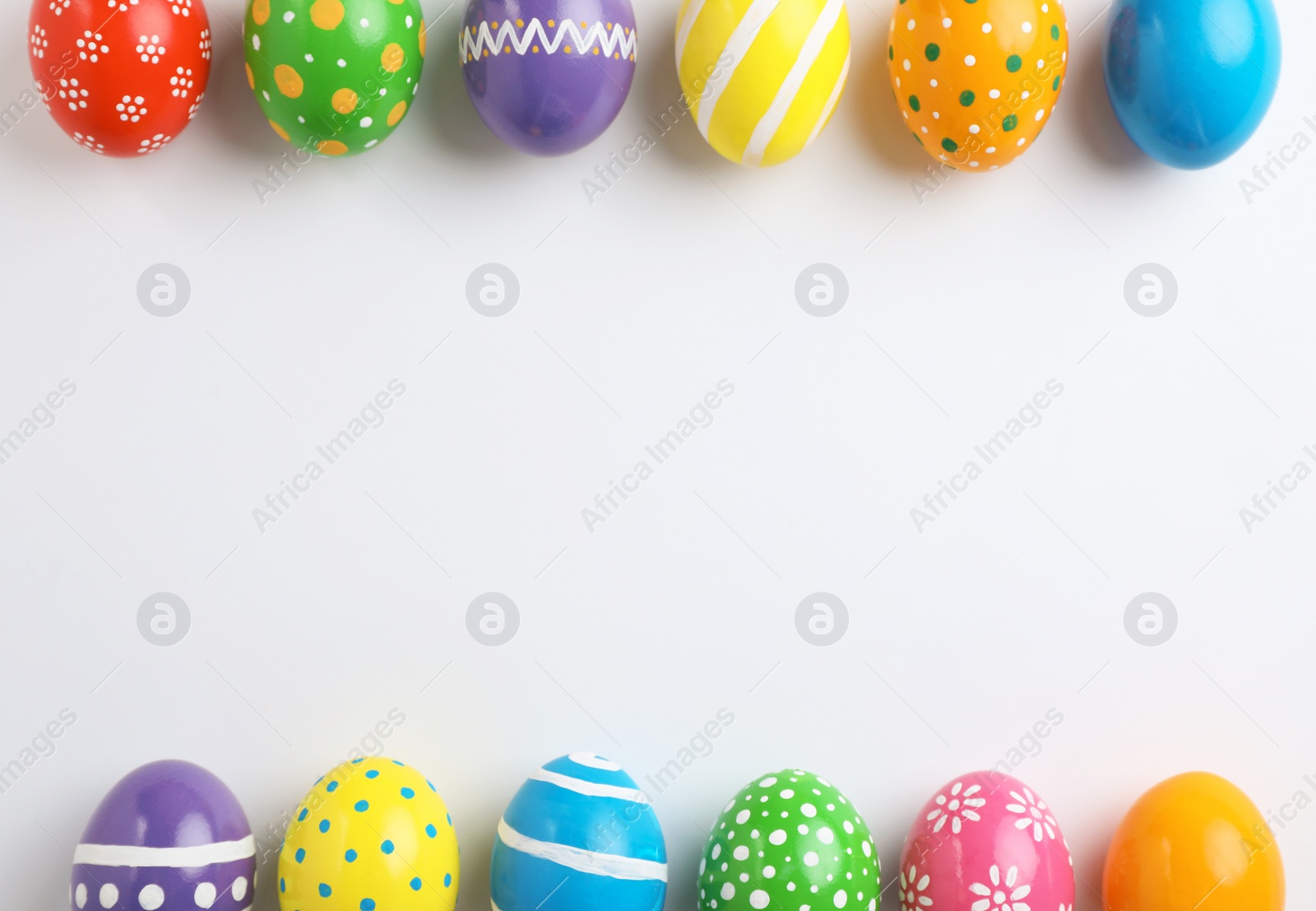 Photo of Decorated Easter eggs and space for text on white background, top view