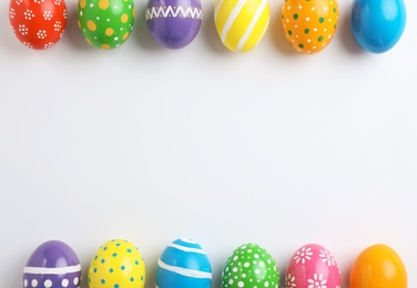 Decorated Easter eggs and space for text on white background, top view