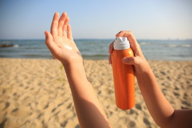 Child applying sunscreen near sea, closeup. Sun protection care