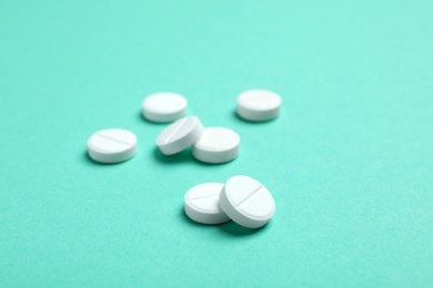 Photo of White pills on color background, closeup