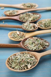 Photo of Spoons with aromatic dried lemongrass on light blue wooden table