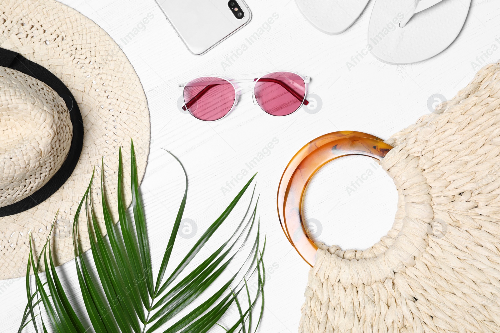 Photo of Flat lay composition with beach bag and accessories on white wooden background
