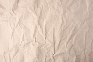 Photo of Sheet of crumpled light brown paper as background, top view