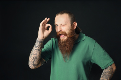 Photo of Bearded man in green shirt on black background. St. Patrick's Day celebration