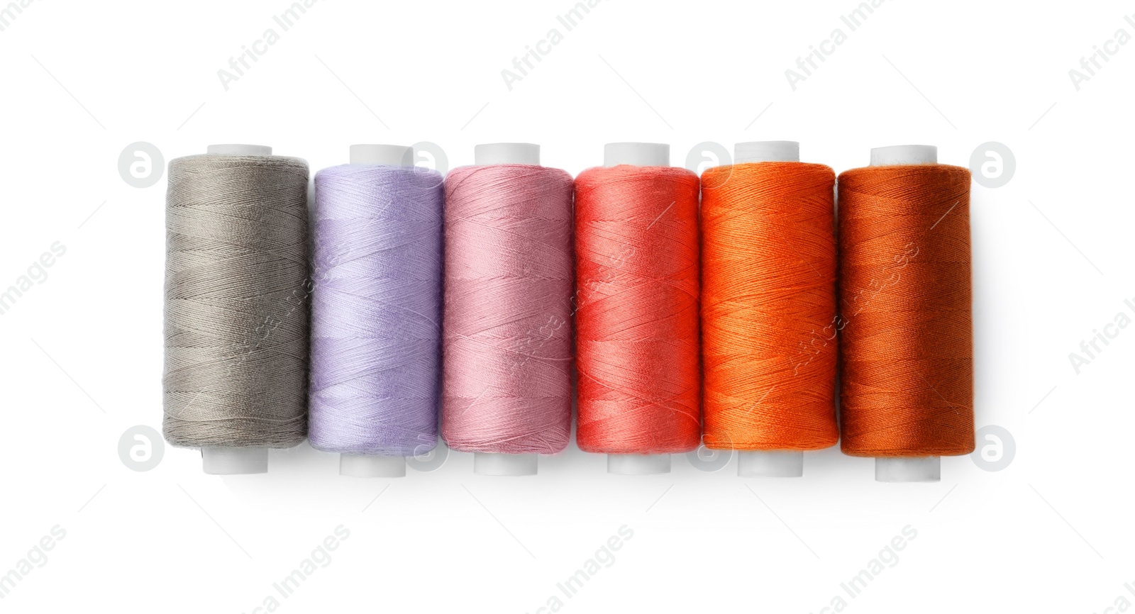 Photo of Set of different colorful sewing threads on white background, top view