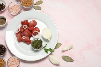 Raw beef meat and different ingredients for cooking delicious goulash on pink marble table, above view. Space for text