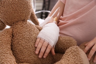 Little child with intravenous drip and toy in hospital, closeup