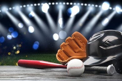 Image of Baseball bat, glove, helmet and ball on wooden table at stadium. Space for text