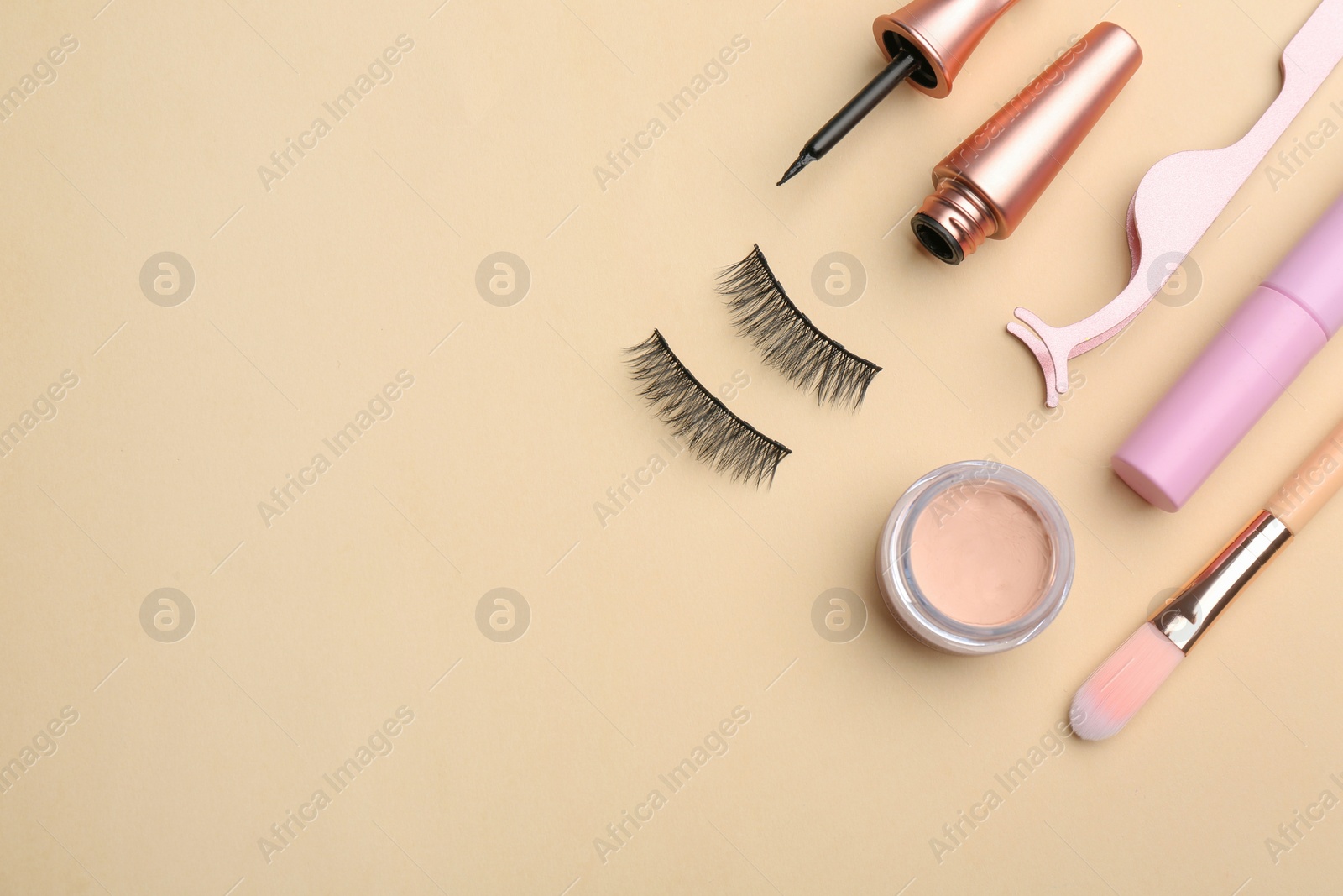 Photo of Flat lay composition with magnetic eyelashes and accessories on beige background. Space for text