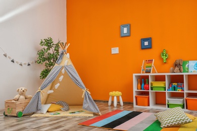 Cozy kids room interior with play tent and toys