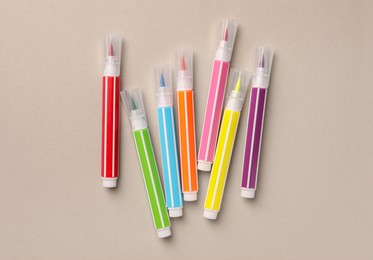 Photo of Many bright markers on light grey background, flat lay