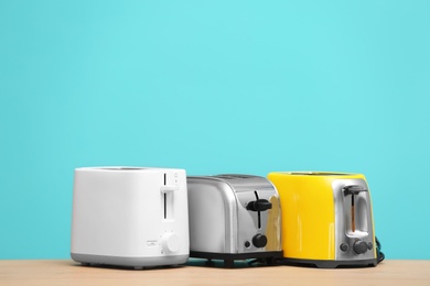 Photo of Different toasters on table against color background. Interior element