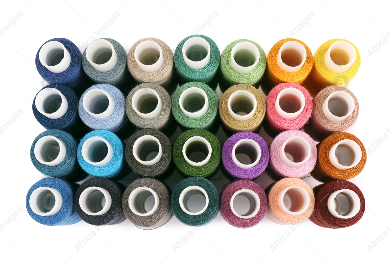 Photo of Set of colorful sewing threads on white background, top view