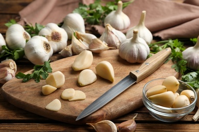 Fresh whole and cut garlic on wooden table. Organic product