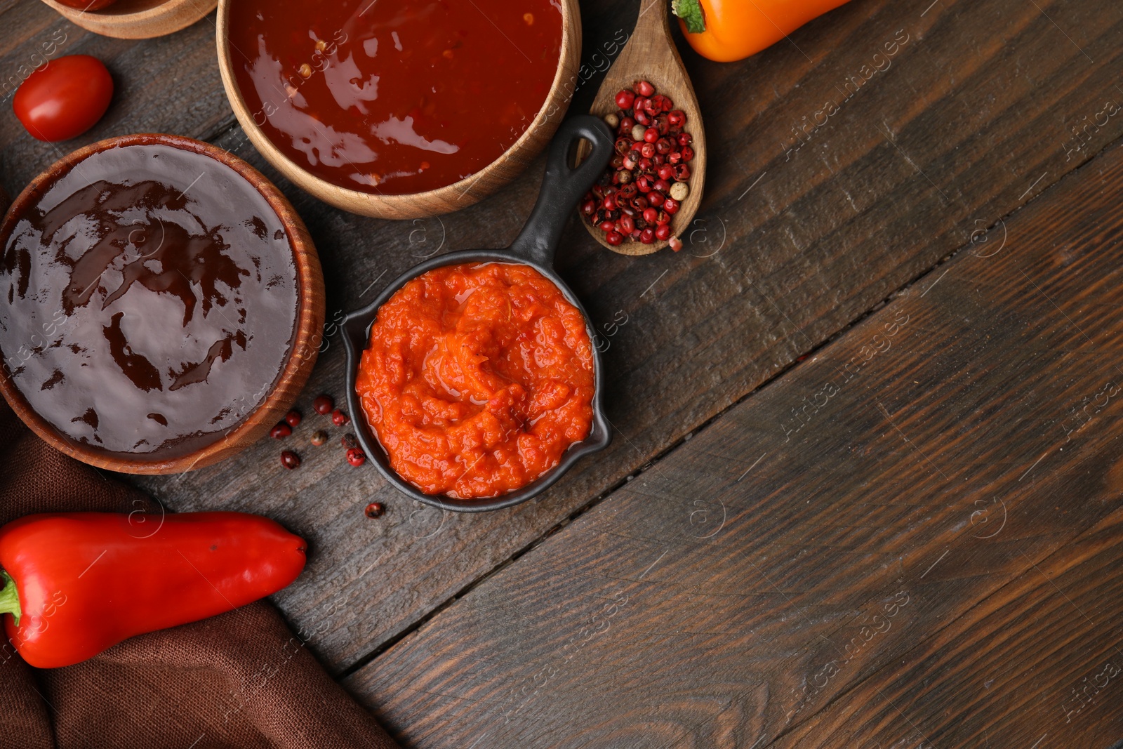 Photo of Different marinades and products on wooden table, flat lay. Space for text