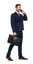 Handsome bearded businessman in suit with briefcase talking on smartphone against white background