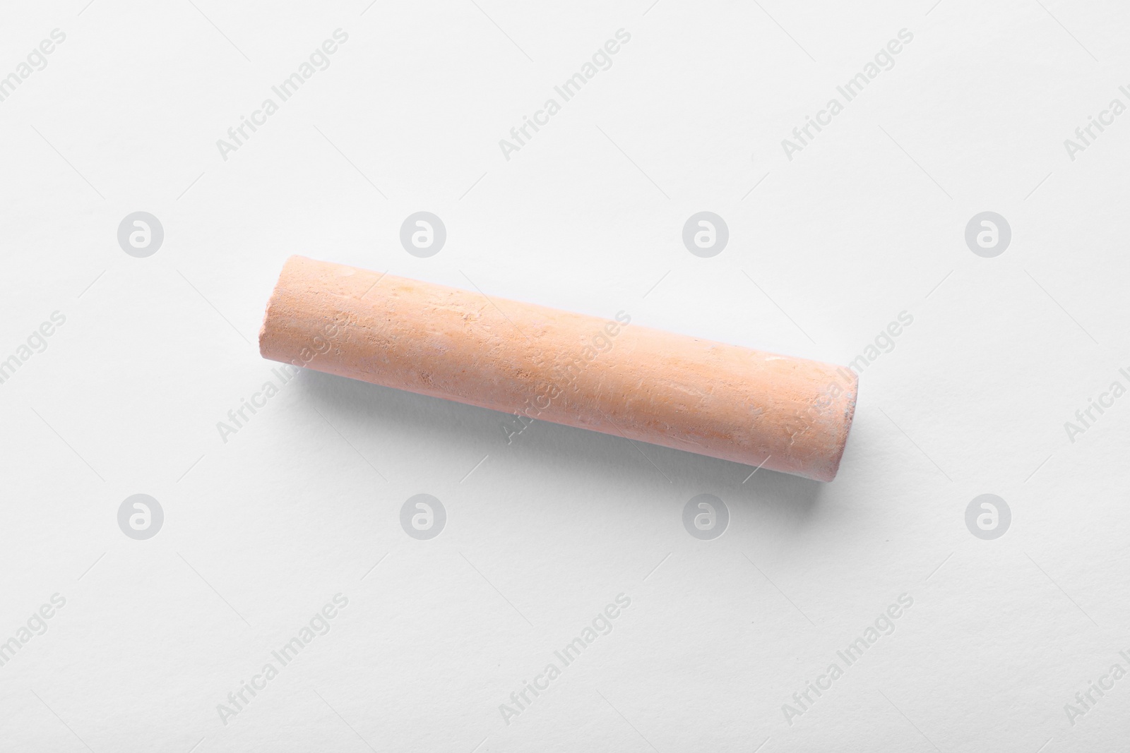 Photo of Piece of orange chalk isolated on white, top view