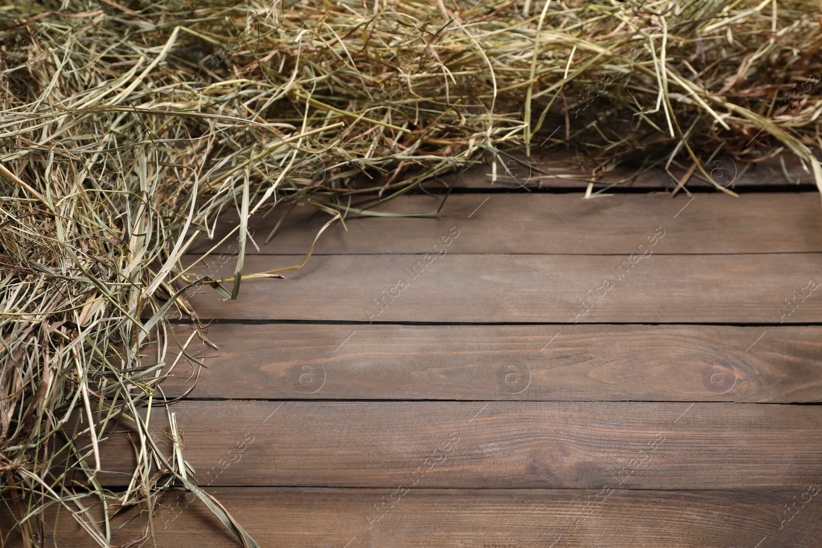 Photo of Frame made of dried hay on wooden table, top view. Space for text