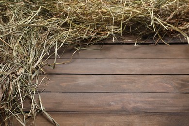 Photo of Frame made of dried hay on wooden table, top view. Space for text