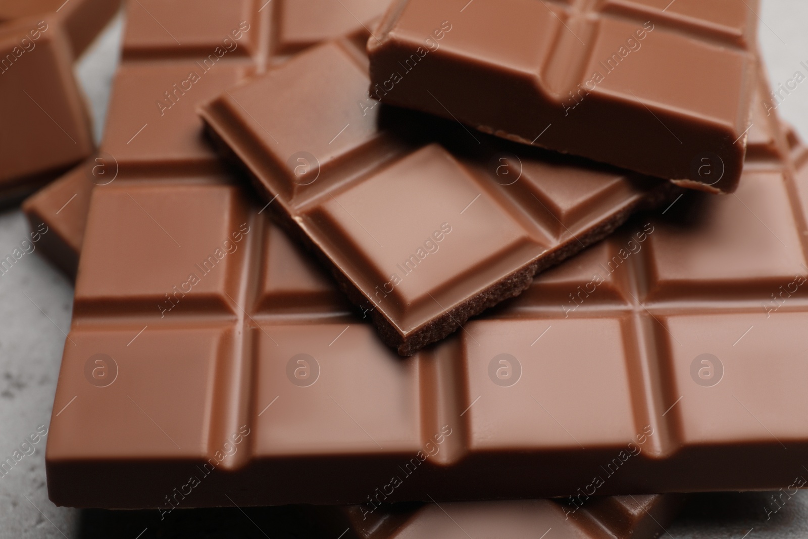 Photo of Delicious milk chocolate on light grey table, closeup