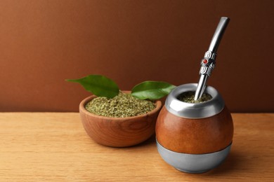 Calabash with mate tea and bombilla on wooden table