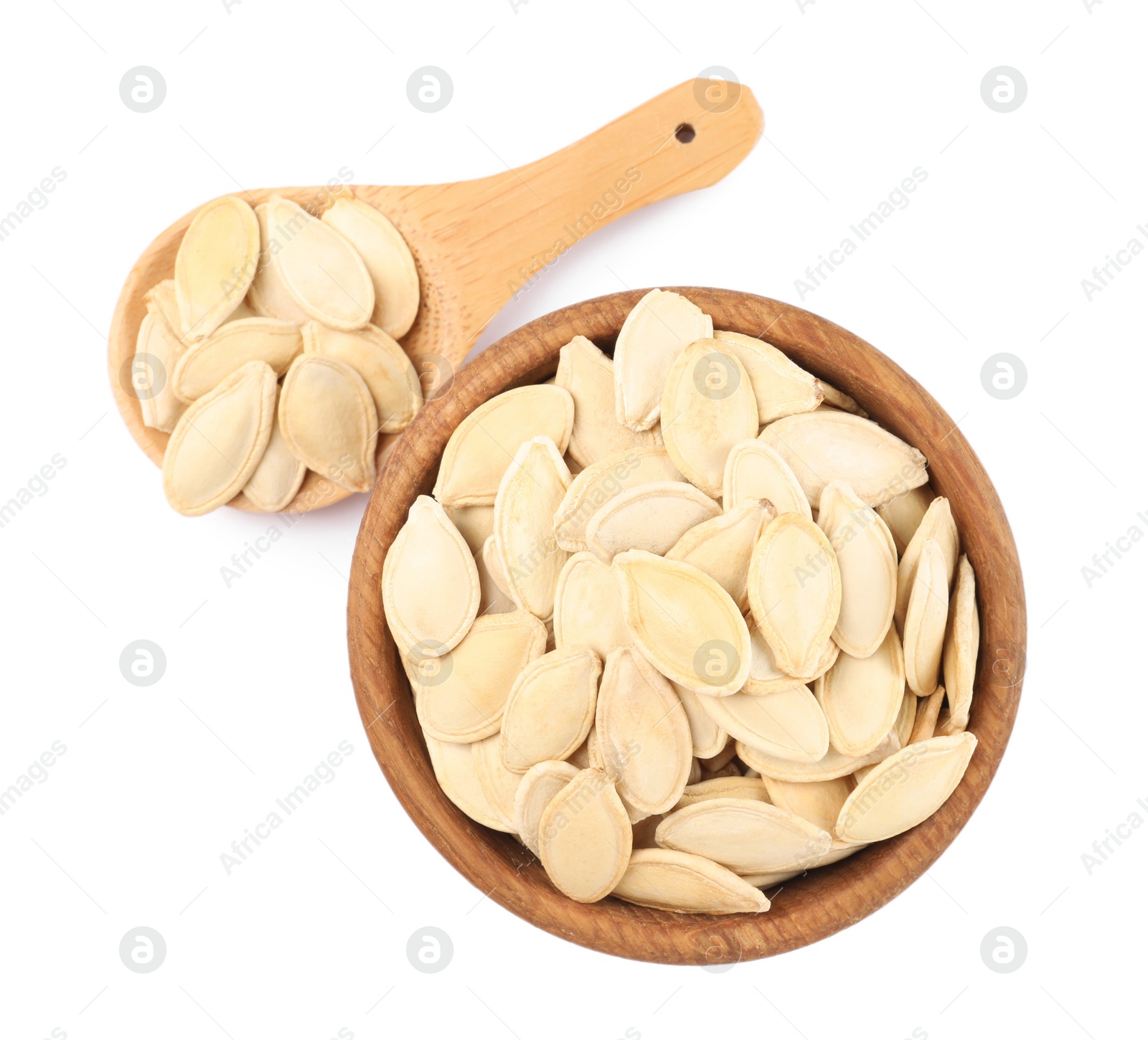 Photo of Wooden bowl and spoon with pumpkin seeds isolated on white, top view