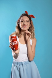 MYKOLAIV, UKRAINE - NOVEMBER 28, 2018: Young woman with Coca-Cola can on color background