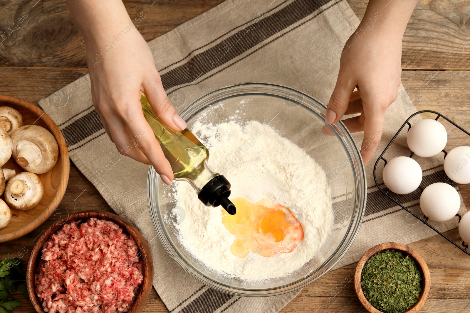 Photo of Woman making dough at wooden table, closeup