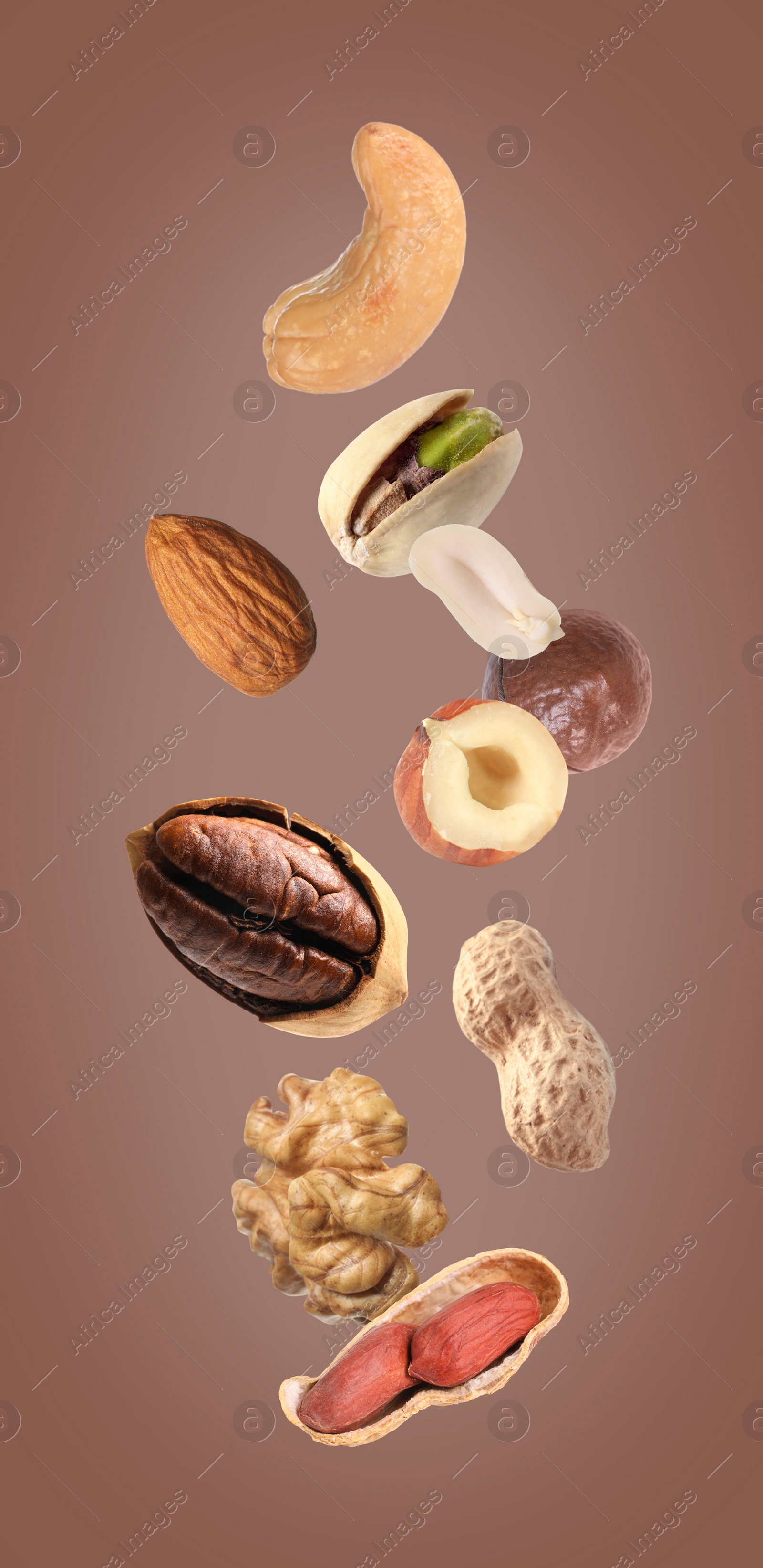 Image of Mix of different nuts in air on brown background