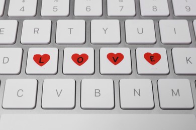 Photo of Laptop keyboard with word Love, closeup. Online dating concept