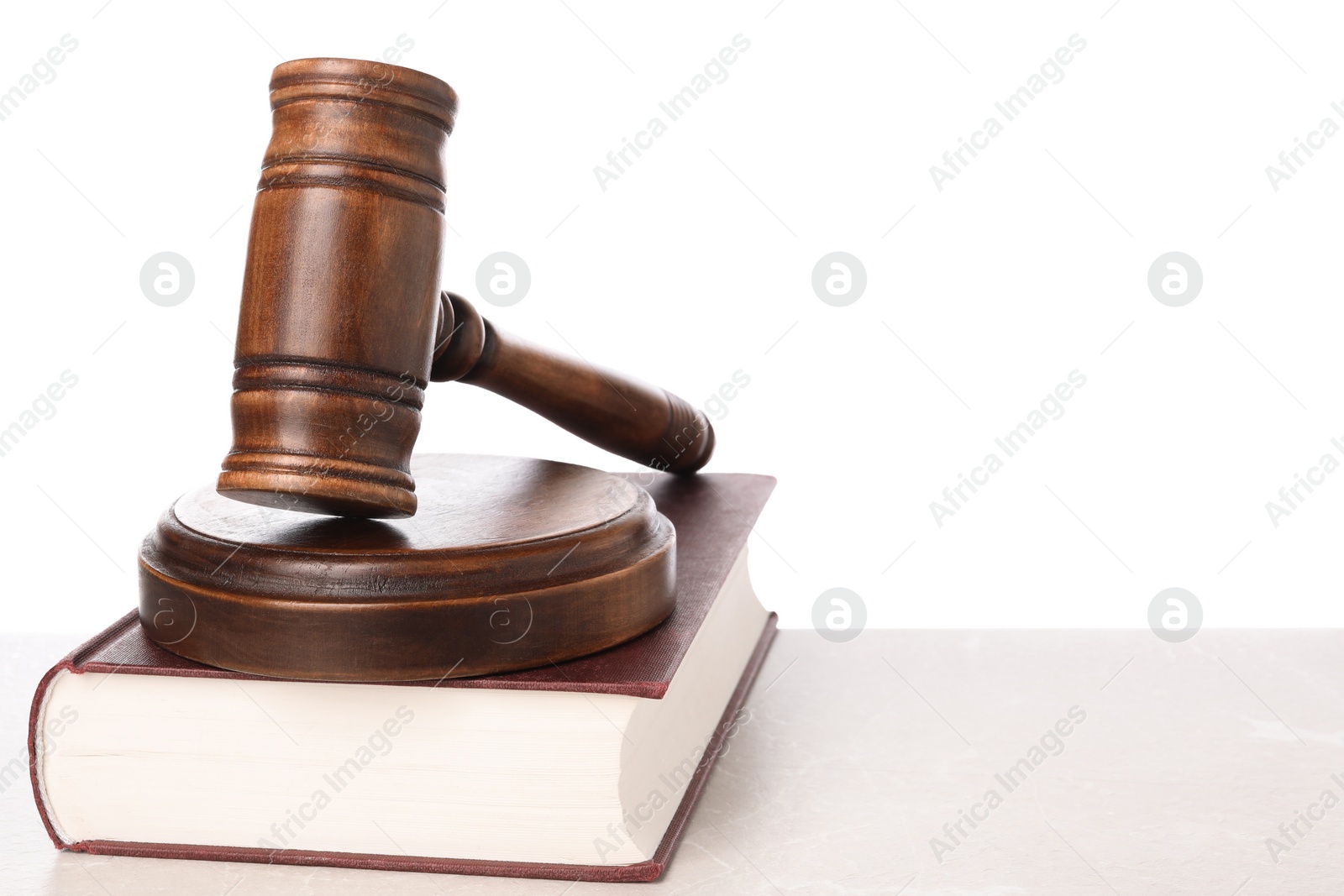 Photo of Wooden gavel, sound block and book on light table against white background. Space for text