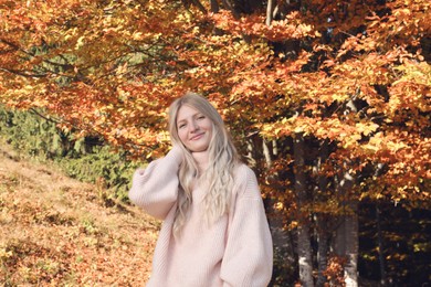 Photo of Portrait of beautiful young woman near forest in autumn