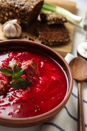 Stylish brown clay bowl with Ukrainian borsch served on white table, closeup