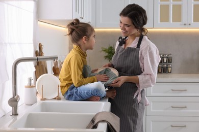 Young mother and her daughter spending time together in kitchen