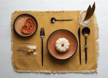 Autumn table setting with pumpkin on white wooden background, flat lay