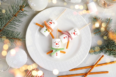 Image of Flat lay composition with funny snowmen made of marshmallows on light marble table. Bokeh effect 
