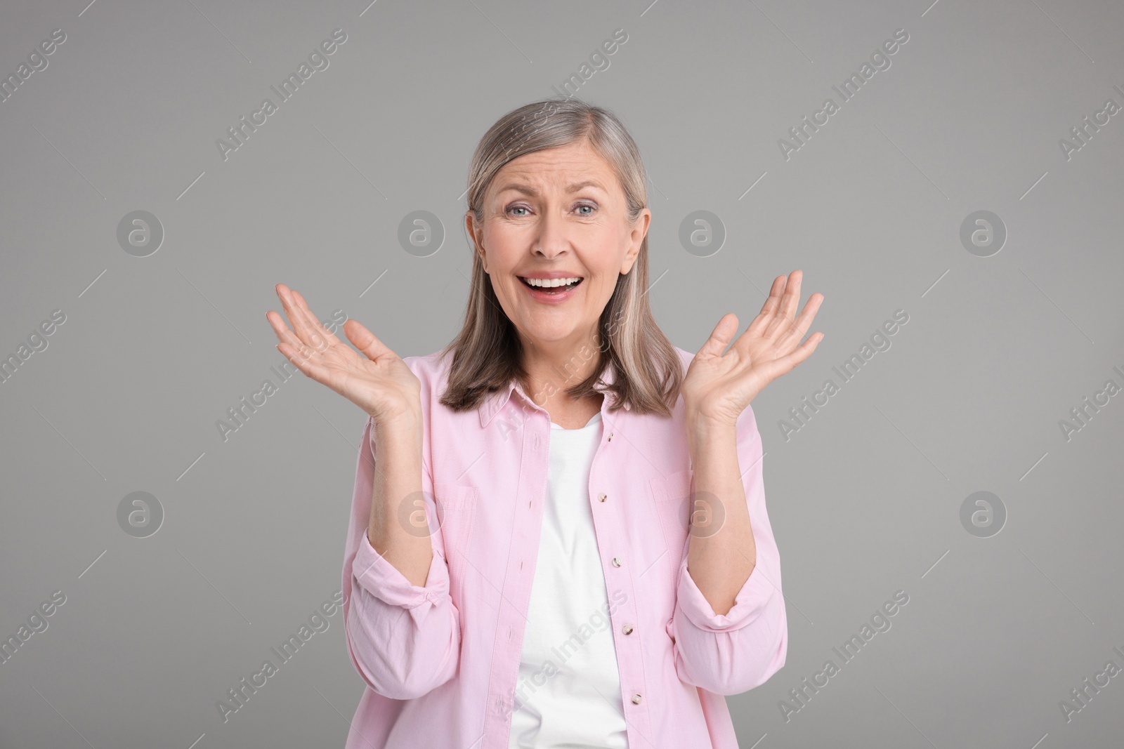 Photo of Portrait of surprised senior woman on grey background