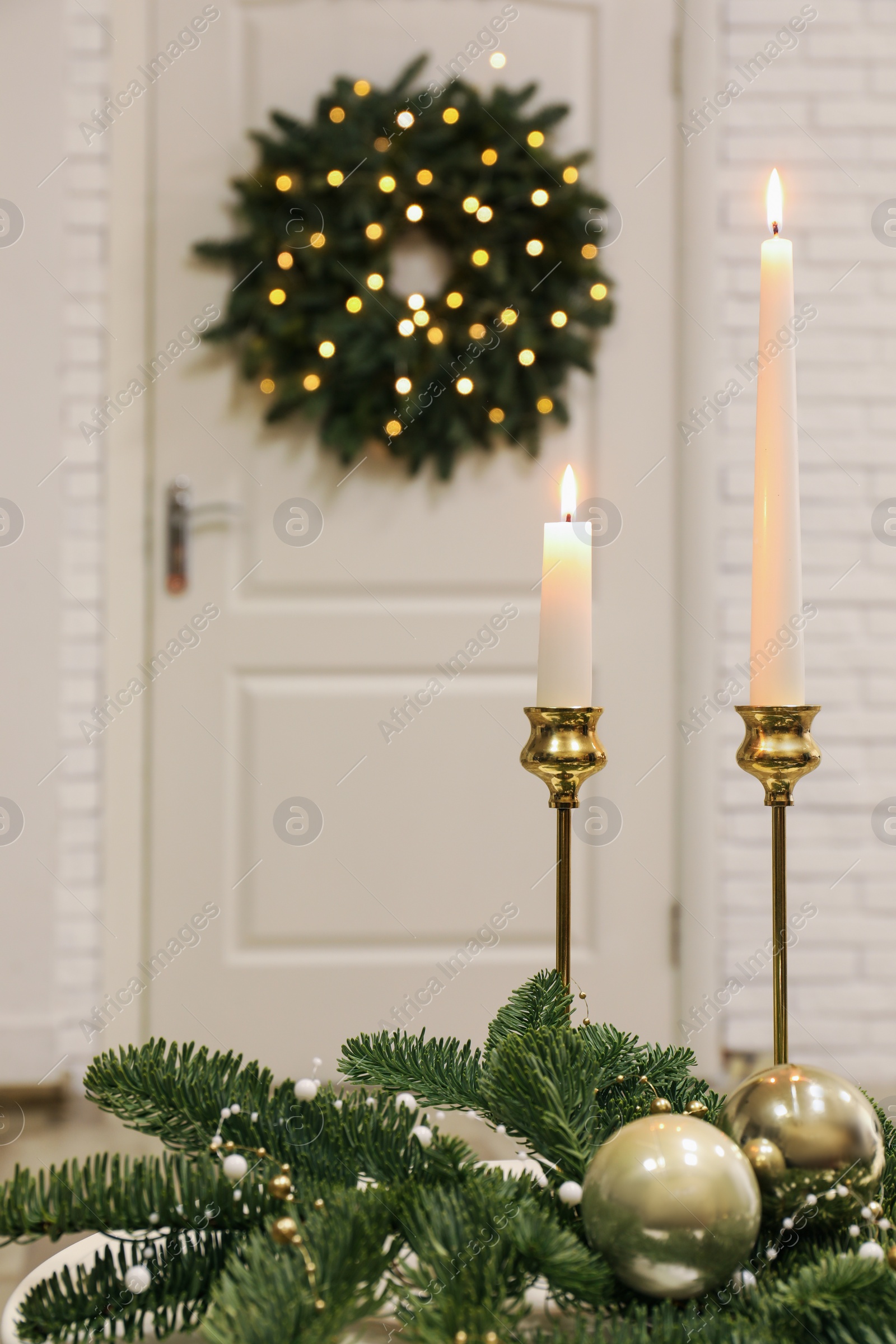 Photo of Christmas composition with burning candles on table in room